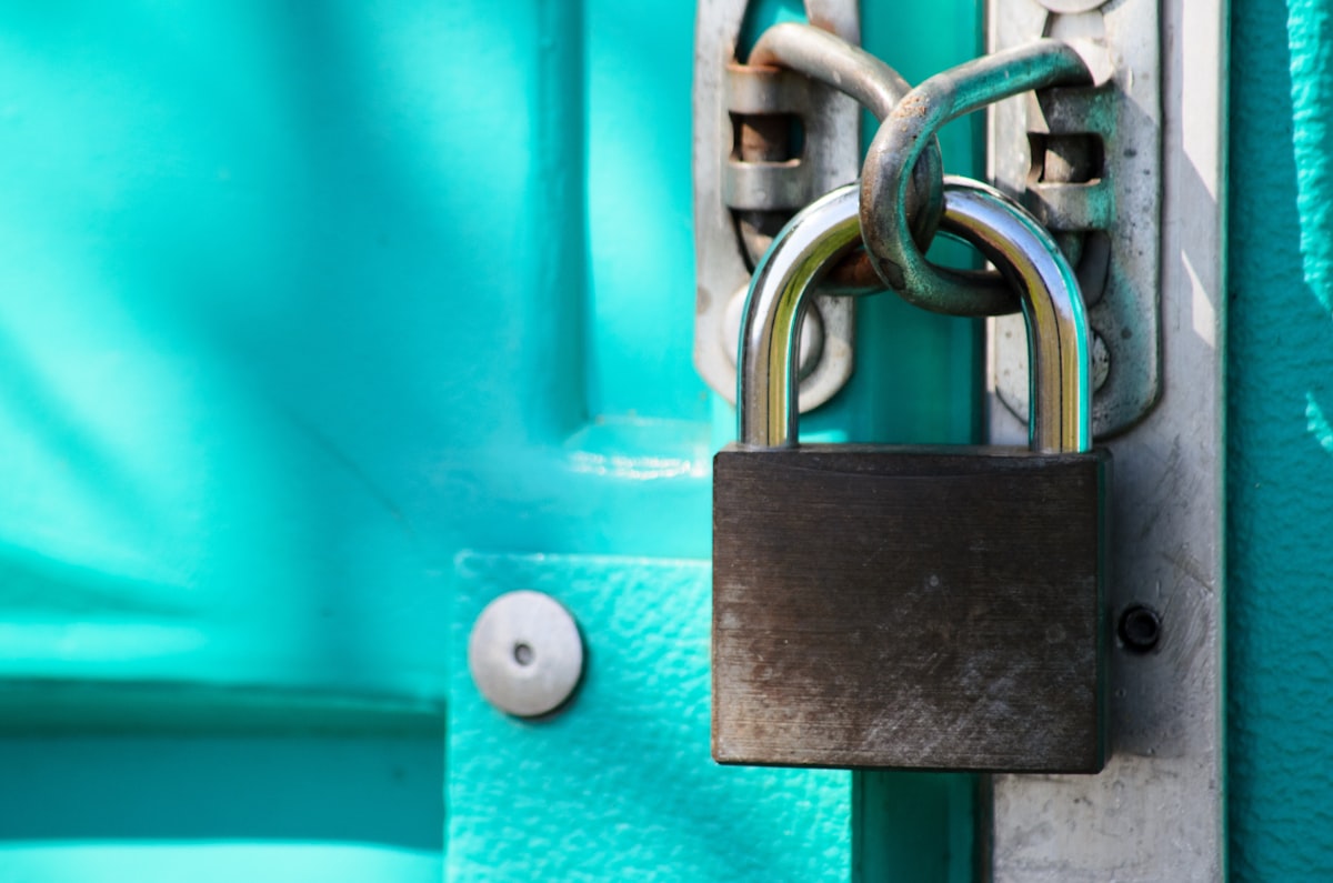 Close-up of a closed padlock on a door — minimal security composition