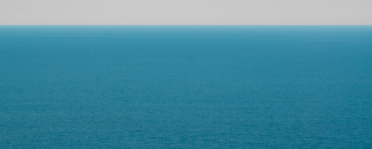 Calm horizon over open water under a soft cloudy sky