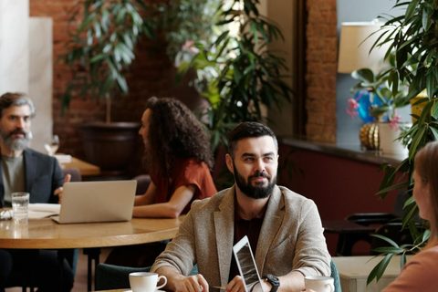 People working and meeting in a café-style venue — the kind of space Reef helps you find
